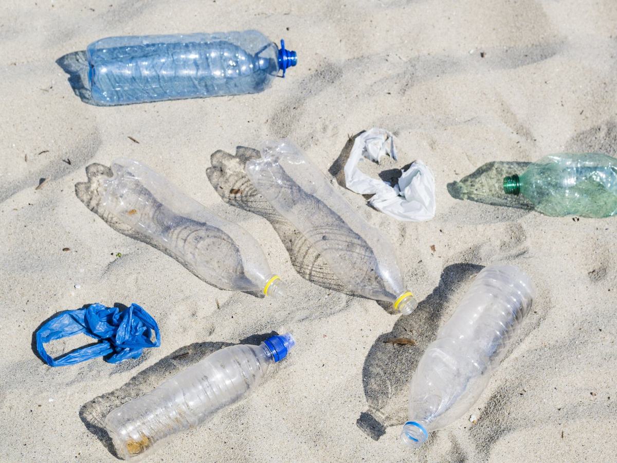 Botellas de plástico vacías abandonadas sobre la arena de una playa